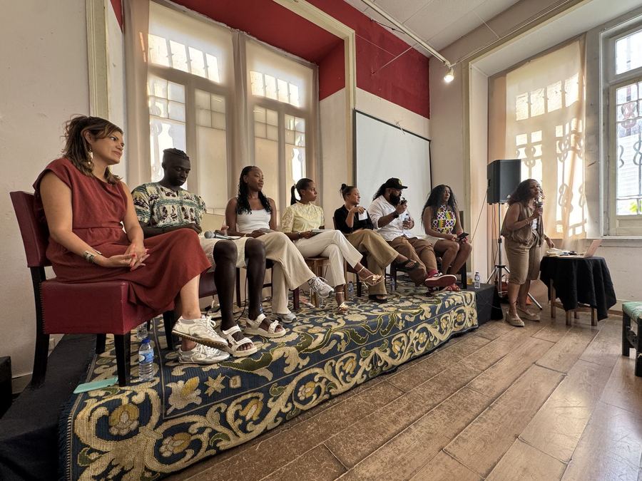 A panel of speakers seated in front of an audience